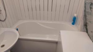 een badkamer met een wit bad en een wastafel bij Лучшее жилье для отпуска в г. Sillamäe in Sillamäe