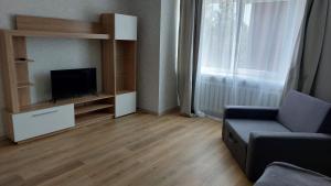 a living room with a tv and a couch and a window at Лучшее жилье для отпуска в г. Sillamäe in Sillamäe