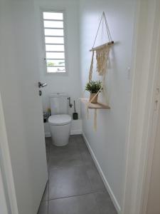 a white bathroom with a toilet and a window at Les Villas Jalnas logement HATEYA in Les Trois-Îlets