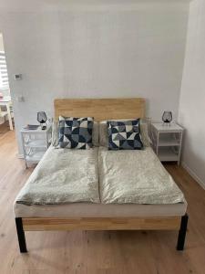 a bedroom with a bed with pillows and two tables at Apartment Mirabelle 4 in Püttlingen