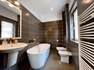 ein Badezimmer mit zwei Waschbecken, einer Badewanne und einem WC in der Unterkunft Apartament la casă în Centrul Orăștiei in Orăştie