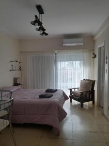 1 dormitorio con 1 cama, 1 silla y 1 ventana en Legarra 1 en Miramar