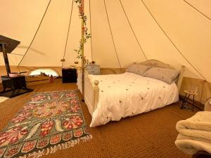 um quarto com uma cama numa tenda em Roe Deer Meadow at Carr House Farm em Scarborough