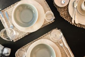 a table with white plates and silverware on it at Studio Apartment 5, Unique Location - Sea View in Lithakia