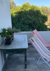 a bench and a chair on a balcony with a table at Casa 1-Quinta dos Penedos in Portalegre