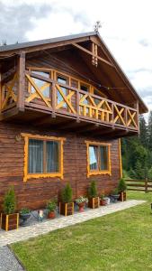 a log cabin with a balcony on top of it at Котедж "Смерековий затишок" in Vorokhta