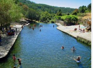 a group of people swimming in a river at Sweet Home - Praia das Rocas in Castanheira de Pêra