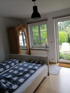 Schlafzimmer mit einem Bett, einem Spiegel und Fenstern in der Unterkunft Wellenbude in Otterndorf
