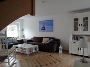 ein Wohnzimmer mit Sofa und Tisch in der Unterkunft Wellenbude in Otterndorf