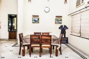 a dining room table with chairs and a clock on a wall at Hotel Ullash Residency Salt Lake Kolkata - fully-air-conditioned-hotel spacious-room with-parking-facility in Salt Lake City