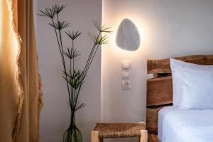 1 dormitorio con 1 cama y un jarrón con una planta en Yianna Sunny Studios, en Skopelos Town