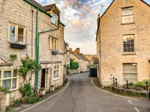 an old street in an english village with stone houses at Farm View Lodge in Stroud