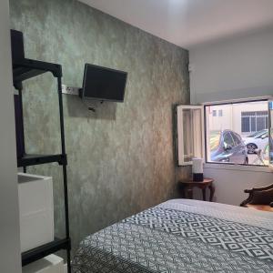 sypialnia z łóżkiem i telewizorem na ścianie w obiekcie VOLPI MAZZO w Madrycie