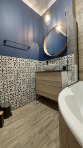 ein Bad mit einem Waschbecken und einem Spiegel in der Unterkunft Glamour Apartman in Gyula