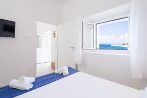 a white room with two beds and a window at Secluded Sea View House - 10m from the Sea in Gdinj