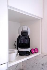 a coffee maker sitting on a shelf in a cupboard at Secluded Sea View House - 10m from the Sea in Gdinj