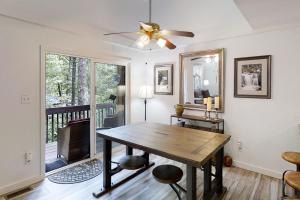 a dining room with a table and a ceiling fan at Whispering Woods Retreat in Sapphire