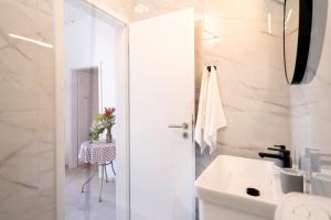 a white bathroom with a sink and a toilet at Secluded Sea View House - 10m from the Sea in Gdinj +110 photos