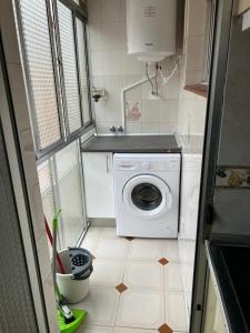 a small kitchen with a washing machine on a tiled floor at C8 Cómodo piso de 3 habitaciones cerca del centro de Madrid in Madrid