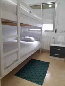 a bedroom with two bunk beds and a rug at C8 Cómodo piso de 3 habitaciones cerca del centro de Madrid in Madrid