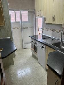 a kitchen with a stove and a sink in it at C8 Cómodo piso de 3 habitaciones cerca del centro de Madrid in Madrid