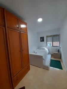 sypialnia z łóżkiem i dużą drewnianą szafką w obiekcie C8 Cómodo piso de 3 habitaciones cerca del centro de Madrid w Madrycie