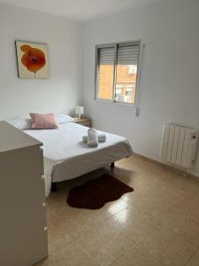 biała sypialnia z łóżkiem i oknem w obiekcie C8 Cómodo piso de 3 habitaciones cerca del centro de Madrid w Madrycie