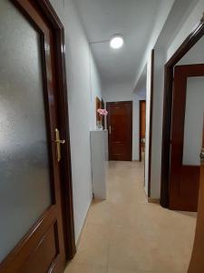 a hallway with a door and a refrigerator in a room at C8 Cómodo piso de 3 habitaciones cerca del centro de Madrid in Madrid