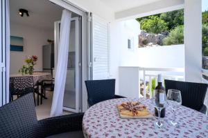 a dining room with a table with a bottle of wine at Secluded Sea View House - 10m from the Sea in Gdinj