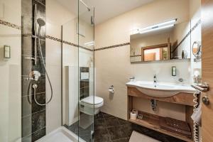 a bathroom with a shower and a sink and a toilet at Landhaus Ifangl in Mayrhofen