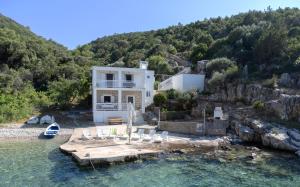 a house with a dock in the water at Secluded Sea View House - 10m from the Sea in Gdinj