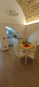 uma sala de jantar com uma mesa e cadeiras e um quadro em Le case di Roberto em Gioia del Colle