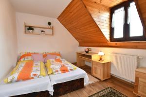 1 dormitorio con cama y techo de madera en PRIVAT MARIANNA en Žakovce