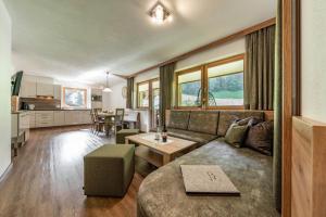 a living room with a couch and a table at Landhaus Ifangl in Mayrhofen