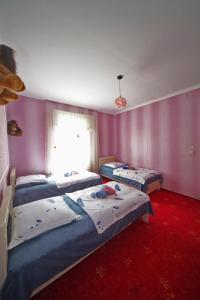 2 camas en una habitación con paredes moradas en VILLA TAMARISI, en Rokit'i