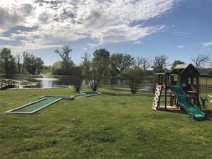 zwei Spielplatzgeräte in einem Park mit Teich in der Unterkunft Bass Capital Rentals LLC in Quitman