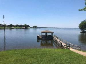 a dock with a gazebo in the middle of a lake at Bass Capital Rentals LLC in Quitman