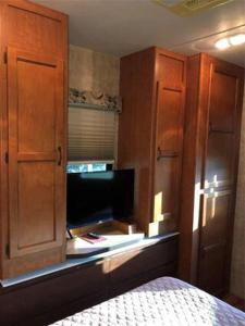 ein Schlafzimmer mit einem Bett, einem Schrank und einem TV in der Unterkunft Bass Capital Rentals LLC in Quitman
