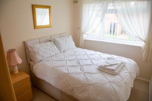 a white bed in a bedroom with a window at St Margaret's Bay Holiday Let in St Margarets at Cliff