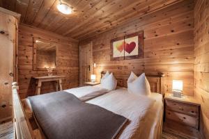 um quarto com uma cama num quarto de madeira em Holzknechthütte em Mayrhofen