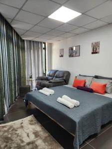 Habitación con cama y sofá en Hotel City Rooms Prishtina en Pristina