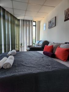Hotel City Rooms Prishtina في بريشتيني: غرفة نوم بسرير كبير عليها مناشف