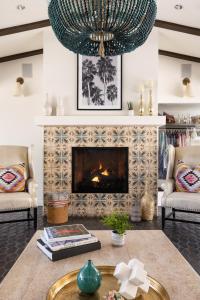 a living room with a fireplace and a chandelier at La Serena Villas, A Kirkwood Collection Hotel in Palm Springs