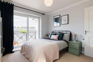 a bedroom with a bed and a large window at Stylish 2 Bed Flat near Station, Parking, Sleeps 6 in Spon End