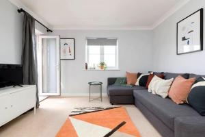a living room with a gray couch and a tv at Stylish 2 Bed Flat near Station, Parking, Sleeps 6 in Spon End