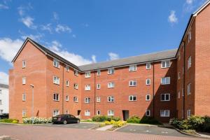 a large red brick building with a parking lot at Stylish 2 Bed Flat near Station, Parking, Sleeps 6 in Spon End