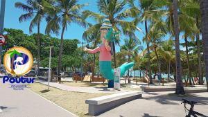 a statue of a mermaid on a pole at a beach at Poutur Pousada in Maceió