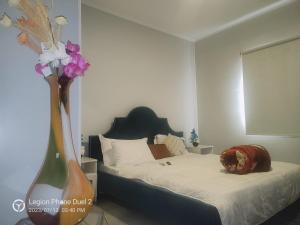 een slaapkamer met een bed en een vaas met bloemen bij قمر الليالي moon of the nights in King Abdullah Economic City
