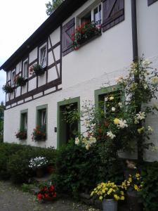 un edificio blanco con flores delante en Urlaub auf dem Bauernhof, en Augustusburg