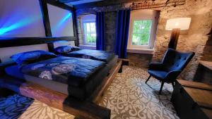 1 dormitorio con 1 cama, 1 silla y ventanas en Urlaub auf dem Bauernhof, en Augustusburg